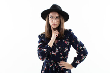 Studio portrait, a woman wearing a dress and hat exudes effortless glamour and sophistication. Her...