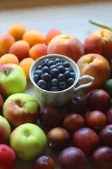 Berries in vintage porcelain dishes, other healthy fruit and vegetable on wooden table. Selective focus.