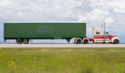 A highway truck hauling freight along a highway. Taken in Alberta, Canada