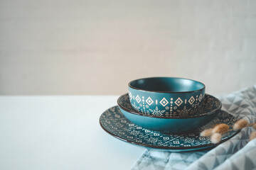 A set of stylish dishes with an ornament on the table on a white background