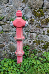Fototapeta na wymiar Red fire hydrant on stone wall background