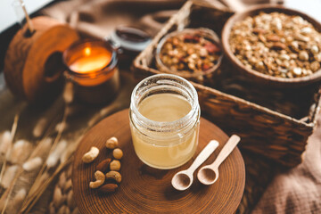 Obraz na płótnie Canvas Jar with natural honey on granola background, good morning concept