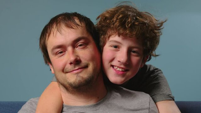 A happy child embraces his father. Portrait of a happy child. Education, care. Parenting a 14 year old teenager
