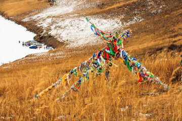 LAKE BAIKAL,RUSSIA-MARCH 1,2023:Ribbons tied in a sacred place for Buddhists.