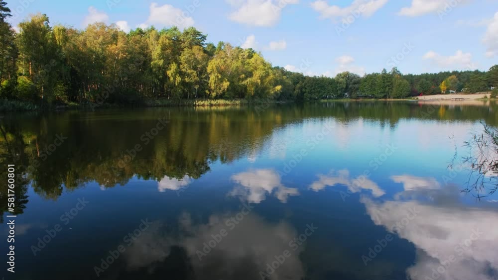 Poster Natural landscape of the lake, high definition, the movement of waves against the background of the autumn forest. The reflection of clouds on the ripples of water. Germany.