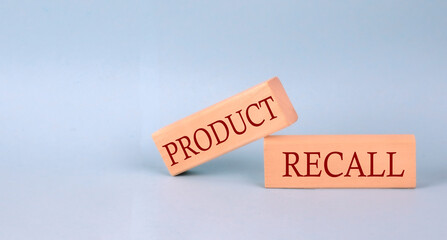 PRODUCT RECALL text on the wooden block, blue background