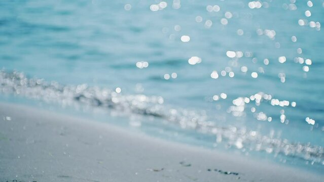 人気のない海辺　キラキラした海　海水浴場の砂浜に押し寄せる波のスローモーション　ヴィンテージでレトロlo-fiな質感で　バブルボケ