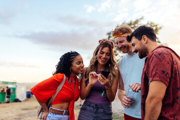 Friends look at band set list for concert on smartphone.