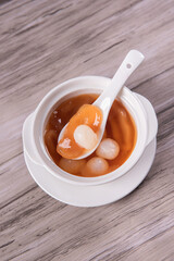 luxury traditional ice cold longan peach gum sea coconut sweet soup in white bowl on wood background asian dessert fresh fruit halal menu