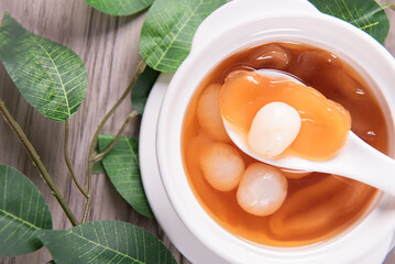 luxury traditional ice cold longan peach gum sea coconut sweet soup in white bowl on wood background asian dessert fresh fruit halal menu