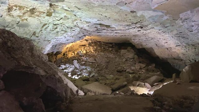 Excursion to the dark ice cave in winter. Underground large stone cave with lakes. Tourism in Russia, the concept of speleology. Kungur ice cave. Perm Region. Underground lakes caves. 4K