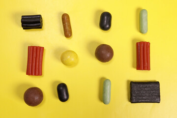 Pattern of colored liquorice sweets on a yellow background