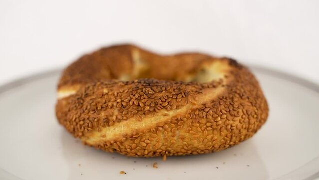 close-up of a Turkish street delicacy sesame bagel in a porcelain plate on a rotating platform