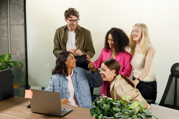 Cheerful people colleagues working together sit at desk look at computer screen discuss new project search solutions joking to increase effective communication concept