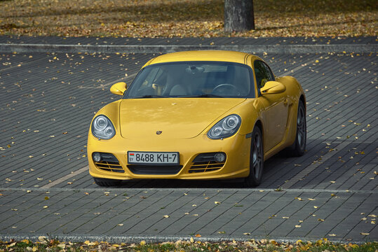 Minsk, Belarus. Sep 2022. Yellow Porsche Cayman S parked in the city in autumn season..