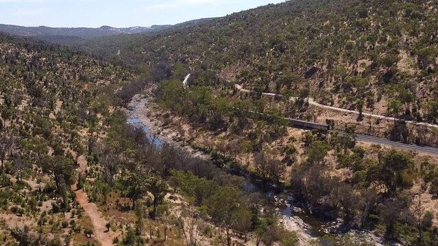 Cinematic Aerial View Of Passenger Train Winding Through Perth Hills At Bells Rapids
