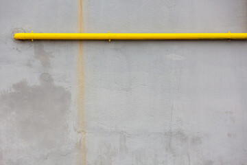 Grey Outside Wall with a Pop of Yellow: Industrial Style Background with Horizontal Pipe