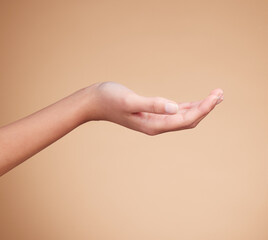 Hands, palm and product placement for mockup in studio isolated on a brown background. Skincare, dermatology and woman model with hand out for marketing, advertising or branding space for mock up.