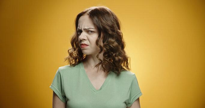 Caucasian model isolated against yellow background selling something sticky and disgusting, intolerable small, holding breath. Bad smells concept.