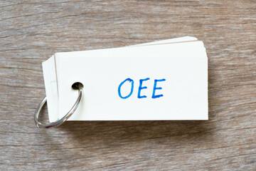 Flash card with handwriting in word OEE (abbreviation of overall equipment effectiveness) on wood...