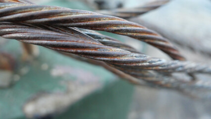 Close up of several strands of twisted metal against green blurred background