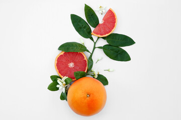 Fresh ripe grapefruits and green leaves on white background, flat lay