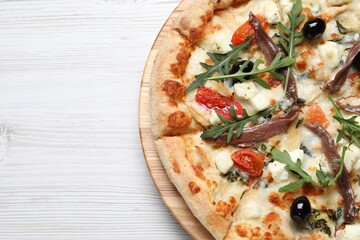 Tasty pizza with anchovies, arugula and olives on white table, top view. Space for text