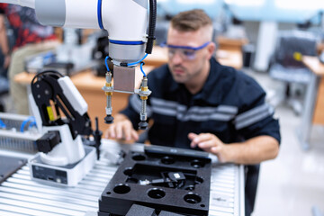 Engineer sitting in robot fabrication room quality checking robot arm hardware engineering