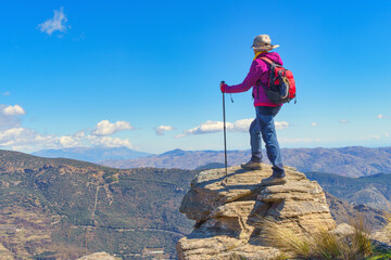 A Woman on Top of the Mountain Enjoying the Impressive Landscape