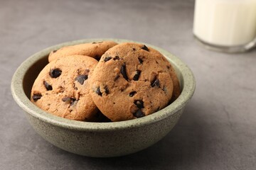 Delicious chocolate chip cookies and milk on grey table, closeup