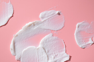 Cosmetics texture. Smear of white face or body cream, lotion, mousse, soap, shower gel on pink background. Spa, skin care, beauty and health, medicine. Cosmetic background, mockup