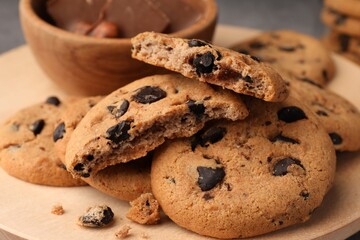 Delicious chocolate chip cookies on wooden tray, closeup