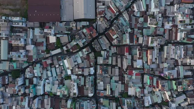 Rooftop view over buildings to timber waiting to be exported at port area along the Saigon river in Ho Chi Minh City, Vietnam. Traffic and buildings can be seen along the road. Top down aerial view.