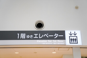 空港内の一階行きのエレベーター看板 - obrazy, fototapety, plakaty