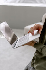 Male hands holding a laptop in the room