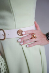 Gold color brooch on the belt. Green dress on the background