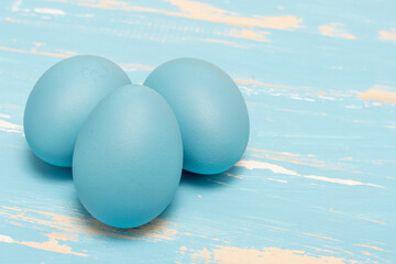 Eggs symbolizing the Easter holiday in blue color on a background of aged wood