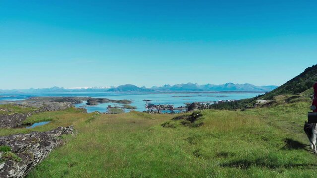 Backpacker Trekking With Husky Dog Near Lovund Island In Nordland County, Norway. Wide Shot