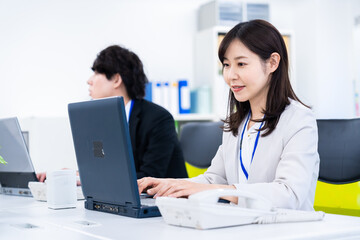 Obraz premium 笑顔でデスクワークをする女性