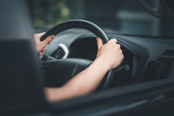 Asian man hand holding steering wheel.