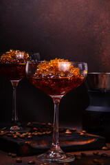 Espresso coffee slush cocktail in martini glass, with craft drips coffee maker. Hard coffee granita, on dark brown background copy space