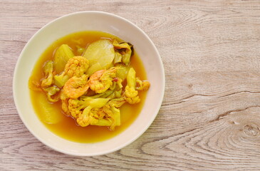 boiled shrimp and mixed vegetable in spicy and sour curry soup on plate