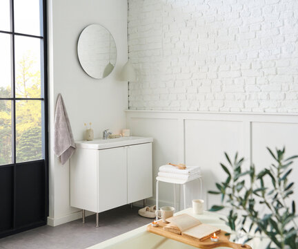 White bathroom, interior concept, cabinet, sink, mirror, accessory and plant, decorative style.