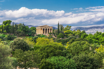 Naklejka premium Athens Greece Temple Of Hephaestus day view surrounded by greenery on a bright sunshine over puffy clouds.