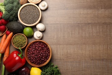Different vegetables on wooden table, flat lay and space for text. Vegan diet
