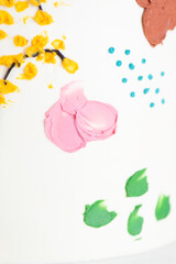 Background of multi-colored drawings on a cake with white cream.