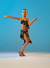 Samba dance. Beautiful little girl in stage attire dancing latino madern ballroom dance over blue...