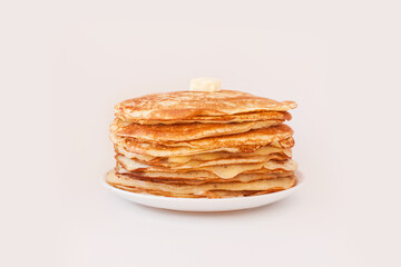 Staple of yeast fluffy pancakes with butter. Spring holiday Traditional Russian Shrovetide Maslenitsa week or pancake tuesday holiday. american crepes isolated on white gray background. side view