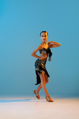 Samba dance. Beautiful little girl in stage attire dancing latino madern ballroom dance over blue...