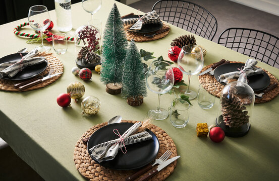 Christmas and new year dinner table serving, green tablecloth, accessory, tree.